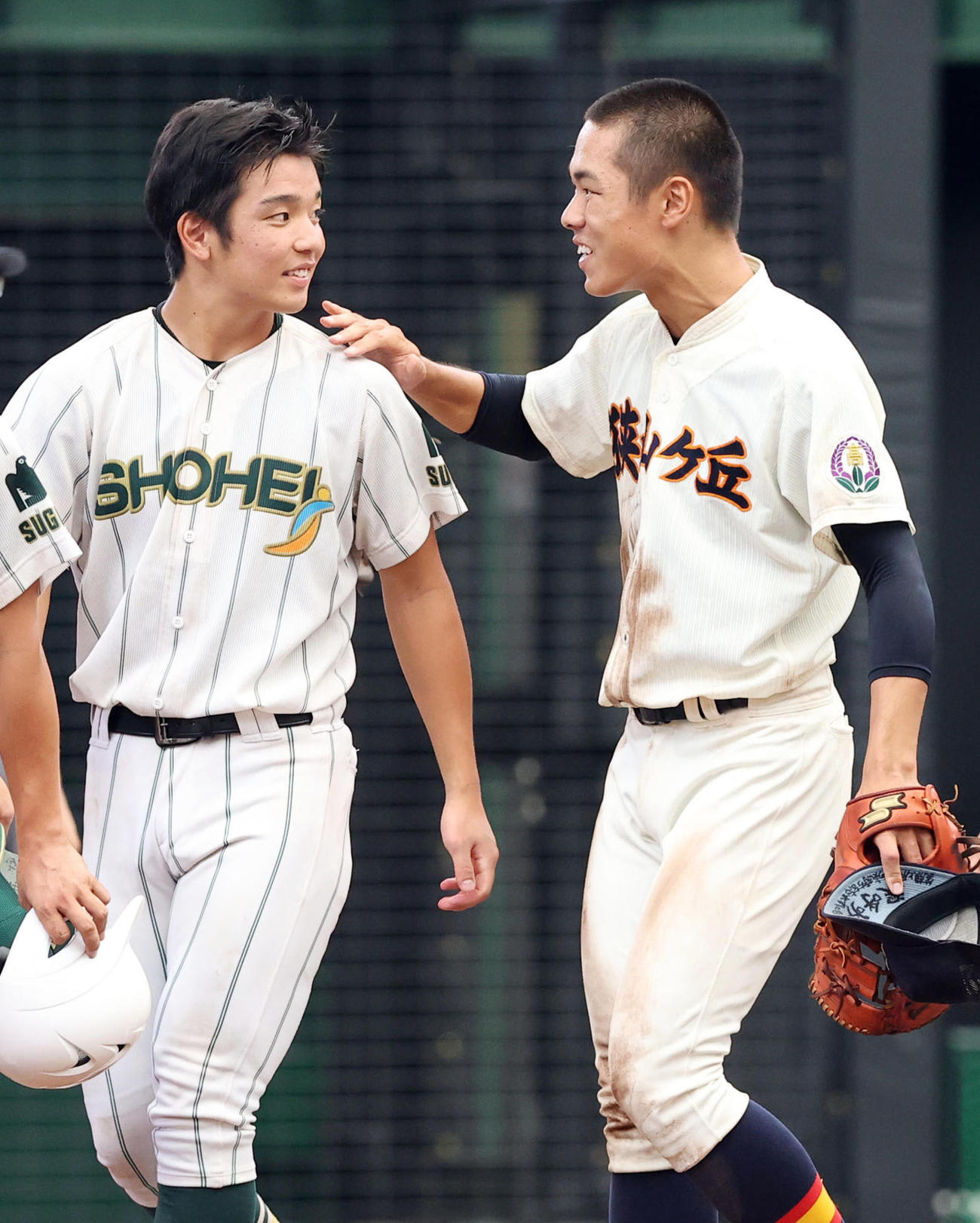 23日、埼玉大会決勝で敗れた昌平・渡辺（左）は狭山ケ丘ナインと笑顔で健闘をたたえ合う