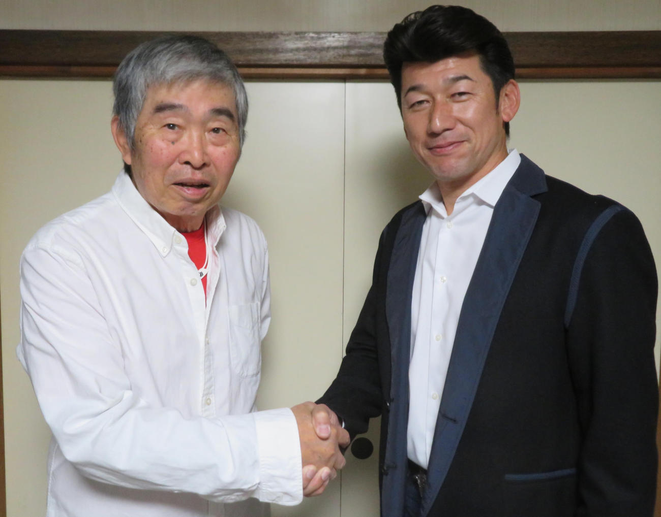 力強く握手する元大洋（現DeNA）の選手だった小谷正勝氏（左）とDeNA三浦大輔監督