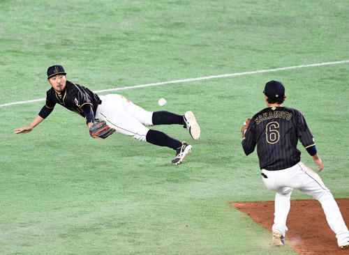 17年3月、WBC2次リーグ・オランダ戦で好捕し、グラブトスする二塁手菊池涼(左)