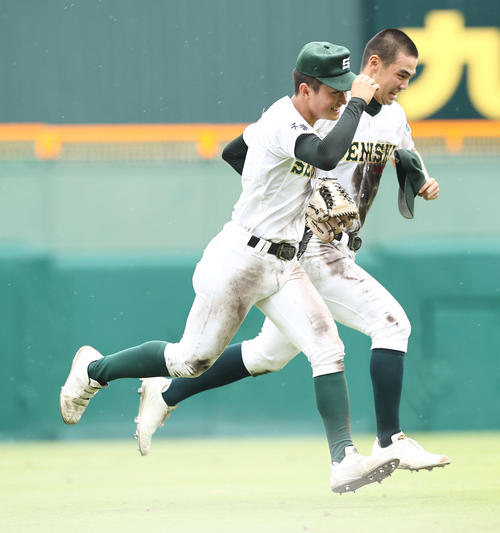 明豊対専大松戸　6回表明豊2死、幸の飛球を追いかけた際に吉岡（右）が落とした帽子を拾ってあげ笑顔のダッシュでベンチに戻る苅部（撮影・垰建太）