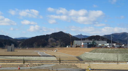 21年3月、写真左半分が震災遺構のビルも残る岩手・陸前高田の旧市街地。右半分が約10メートルかさ上げされた新市街地