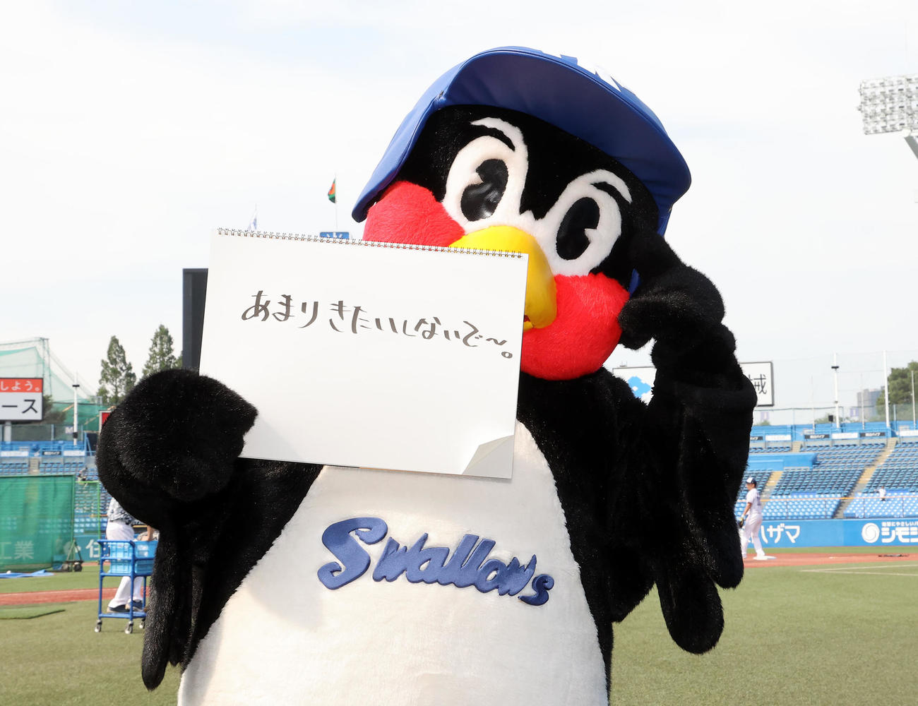 「あまりきたいしないで～。」と書き込んだフリップを手にするつば九郎