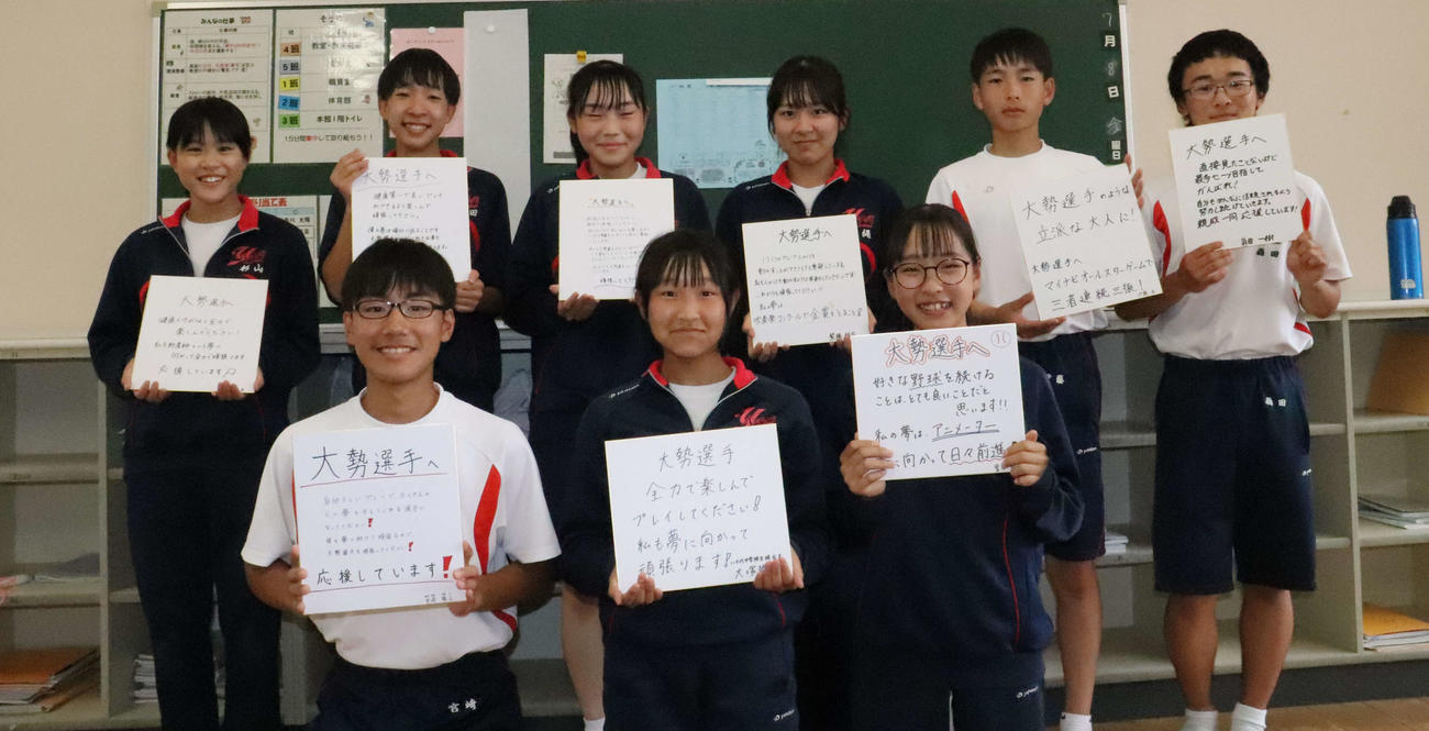 先輩である巨人大勢へのメッセージと自身の夢を記した色紙を手に笑顔を見せる多可町立八千代中の生徒会の生徒たち（撮影・小早川宗一郎）