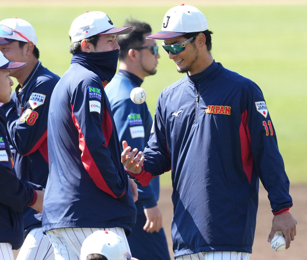 宇田川の名が入ったボールを笑顔で見つめるダルビッシュ。左は佐々木（撮影・菅敏）
