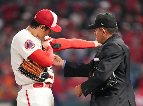 4月11日、球審にピッチコムを見せるエンゼルス大谷(左)