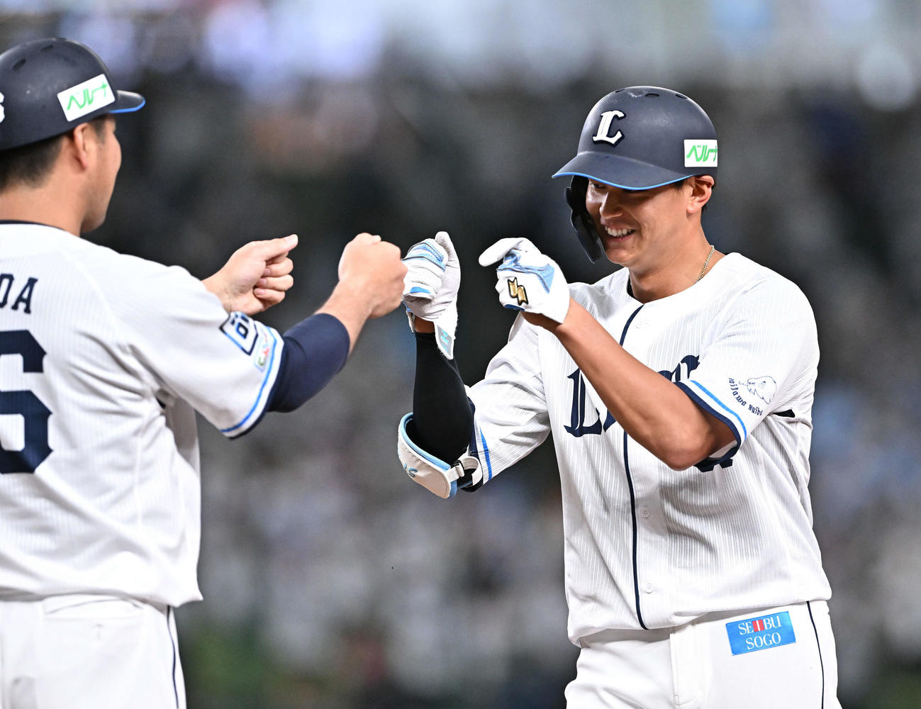 4月30日、中前打を放った西川（右）は赤田外野守備走塁コーチとタッチを交わす