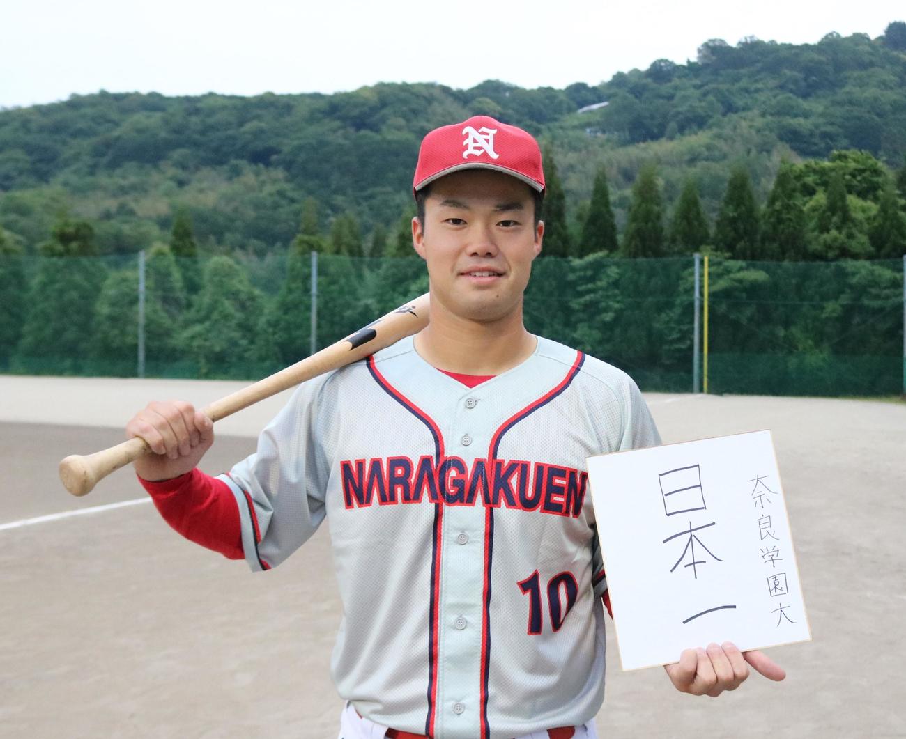 「日本一」と書いた色紙を手にする奈良学園大・松林