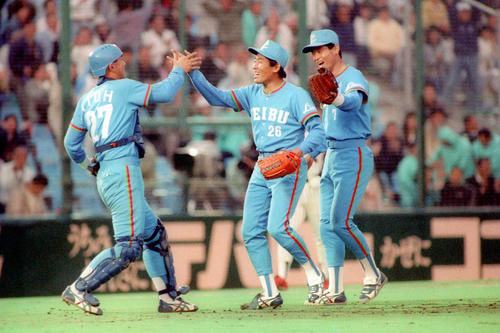 90年4月14日、ダイエー戦で初セーブを挙げた西武鹿取（中央）は捕手伊東とハイタッチ。右は三塁手石毛