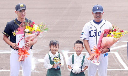 10月8日、フェニックスリーグ西武－阪神戦の開幕セレモニーで花束をもらう阪神矢野2軍監督（左）と西武潮崎2軍監督