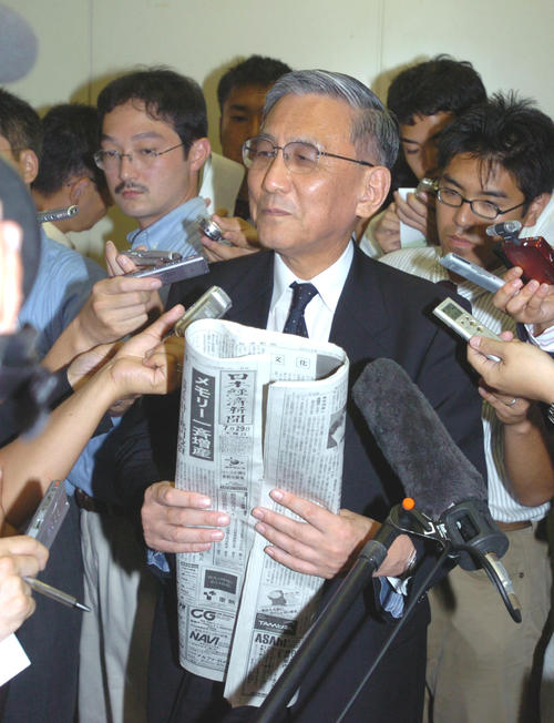 04年7月、ダイエーとの合併を伝える新聞を手に会見するロッテ浜本英輔ロッテ球団社長