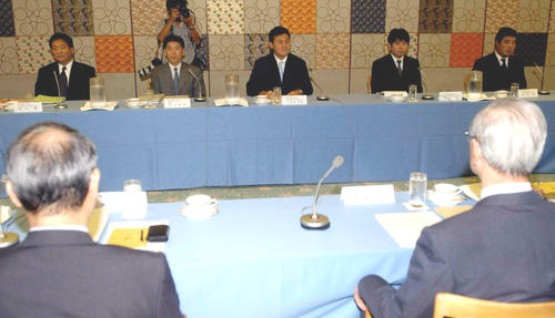 04年10月6日、公開ヒアリングの席に着く楽天・三木谷社長（中央）、手前左はロッテ瀬戸山代表、手前右は審査小委員会の豊蔵委員長