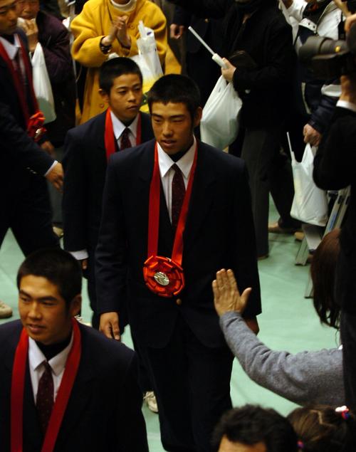 ０９年４月、花巻東準優勝報告会で観衆に見送られ退場する菊池（中央）