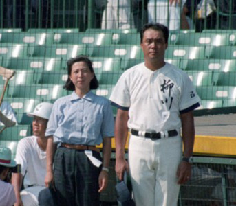 95年8月、柳川の末次監督（右）とともに女性として初のベンチ入りをする高木功美子部長