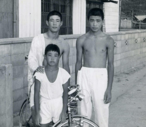 兄2人と西本聖。左上が3男の明和さん、右上が4男正夫さん