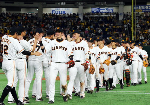 巨人対阪神　阪神に勝ち笑顔でタッチを交わす坂本勇（中央）ら巨人の選手たち（撮影・垰建太）