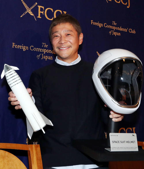 日本外国特派員協会での会見で、自身の月旅行計画のロケット模型とヘルメットを持ち、笑顔を見せるZOZO社長の前沢氏（撮影・狩俣裕三）