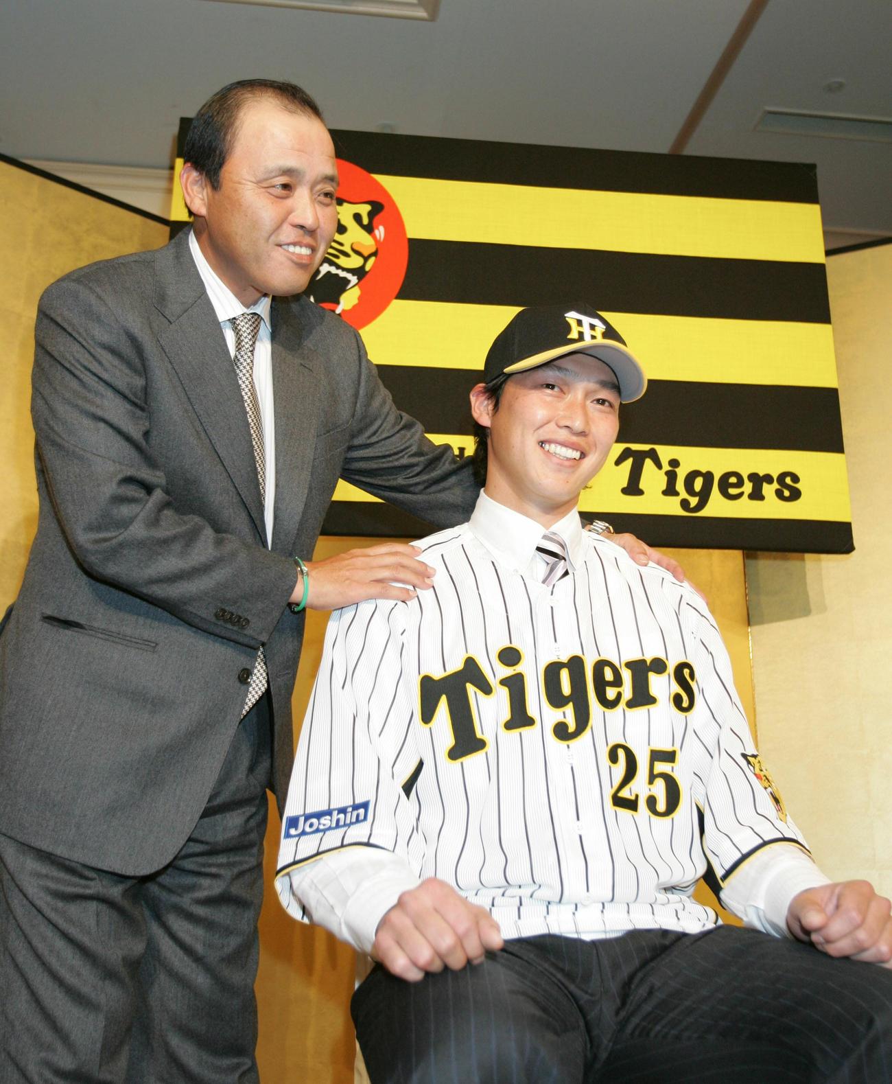 07年12月7日、入団発表の会見でポーズをとる新井（右）と阪神岡田監督