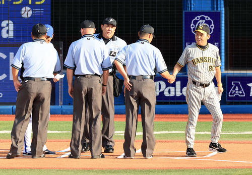 8月20日、DeNA対阪神　試合前のメンバー最終確認で、審判団と笑顔で握手する阪神岡田監督（右）