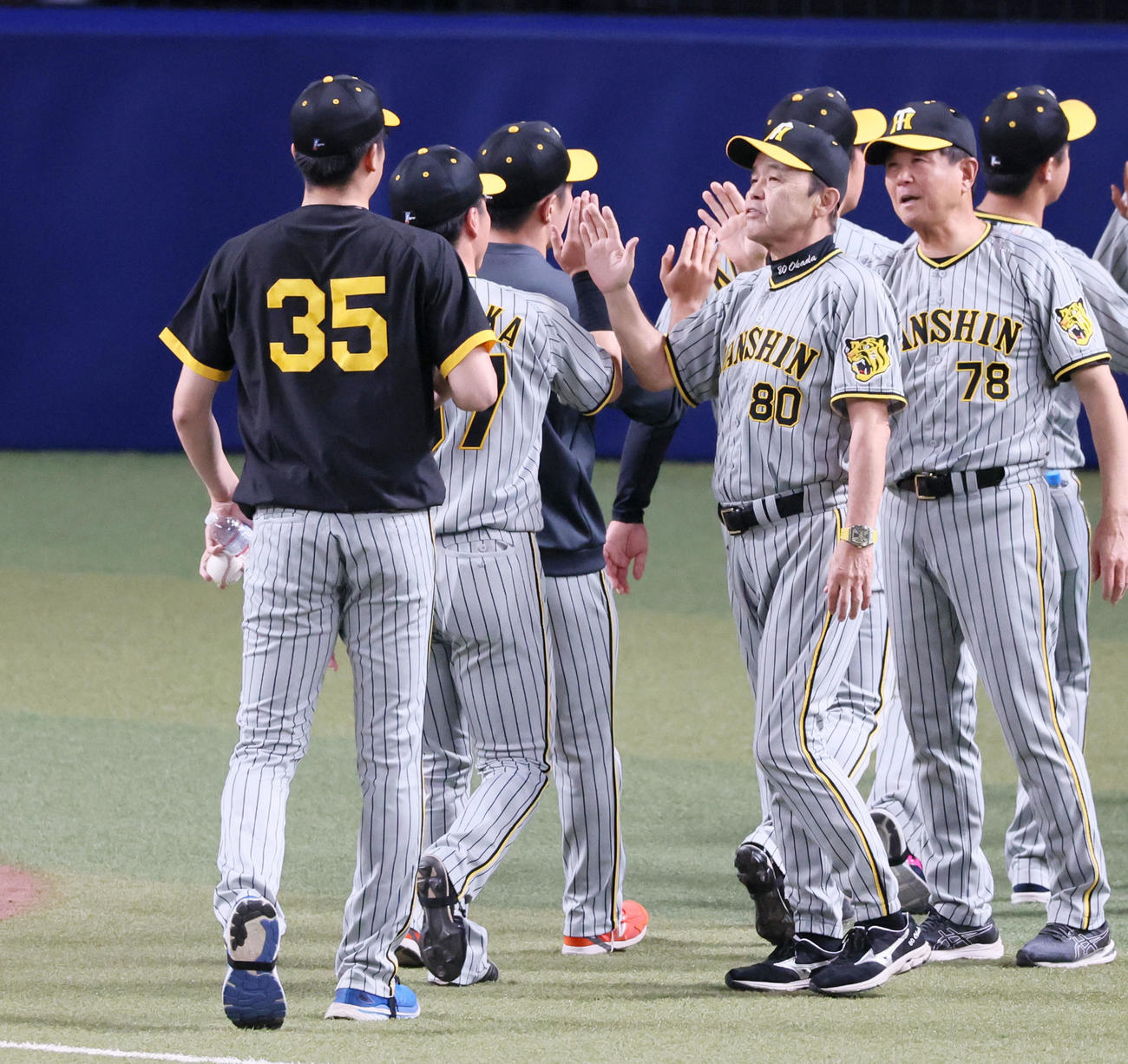 中日に勝利し、才木（左）らナインとタッチする岡田監督（2023年9月6日撮影）