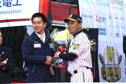 オープニングセレモニーの花束贈呈で握手を交わす、吉村大阪府知事（左）と阪神岡田監督（撮影・村松万里子）