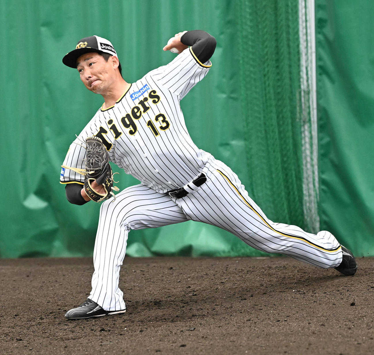 23日、ブルペンで投球練習を行う阪神岩崎優