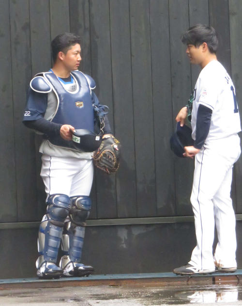 ブルペン投球後に松本（右）と話す西武古賀