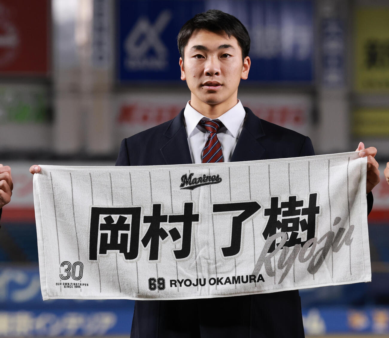 ZOZOマリンスタジアムを見学し、応援タオルを手にするロッテドラフト6位の岡村（2025年12月撮影）