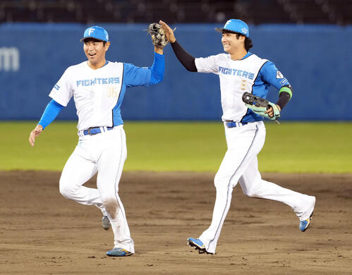 日本ハム対巨人 優勝を飾り宮崎一樹(左)とハイタッチする浅間大基(撮影・たえ見朱実)