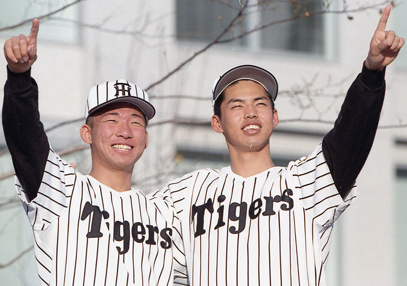 阪神ドラフト2位の井川慶（右）とポーズをとる1位指名の中谷仁（1997年12月18日撮影）