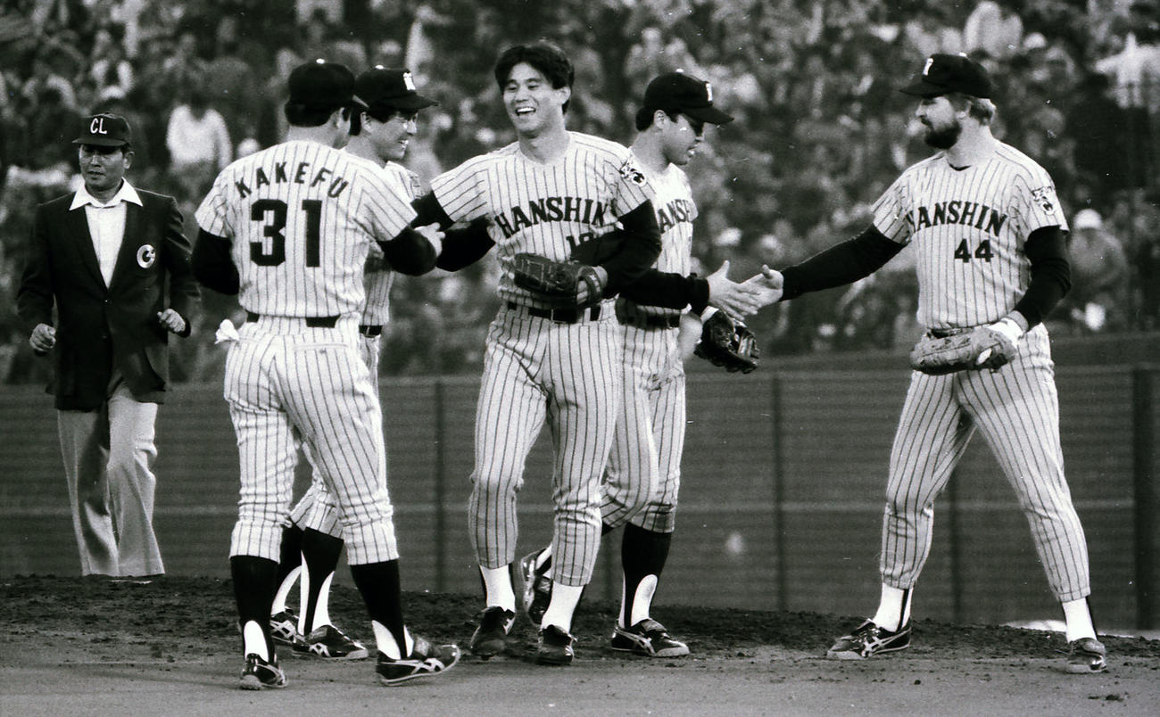 完封勝利を飾り、掛布雅之（左）らナインと握手する池田親興（1985年10月26日撮影）