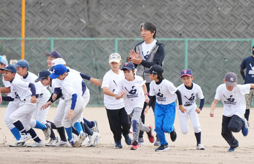 2022年10月15日、野球教室でアップする子供たちを前にする松井氏（右から4人目）