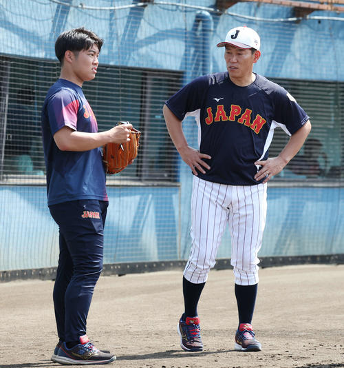 大学日本代表・玉井マネジャー（左）と話す井端臨時コーチ（撮影・宮地輝）