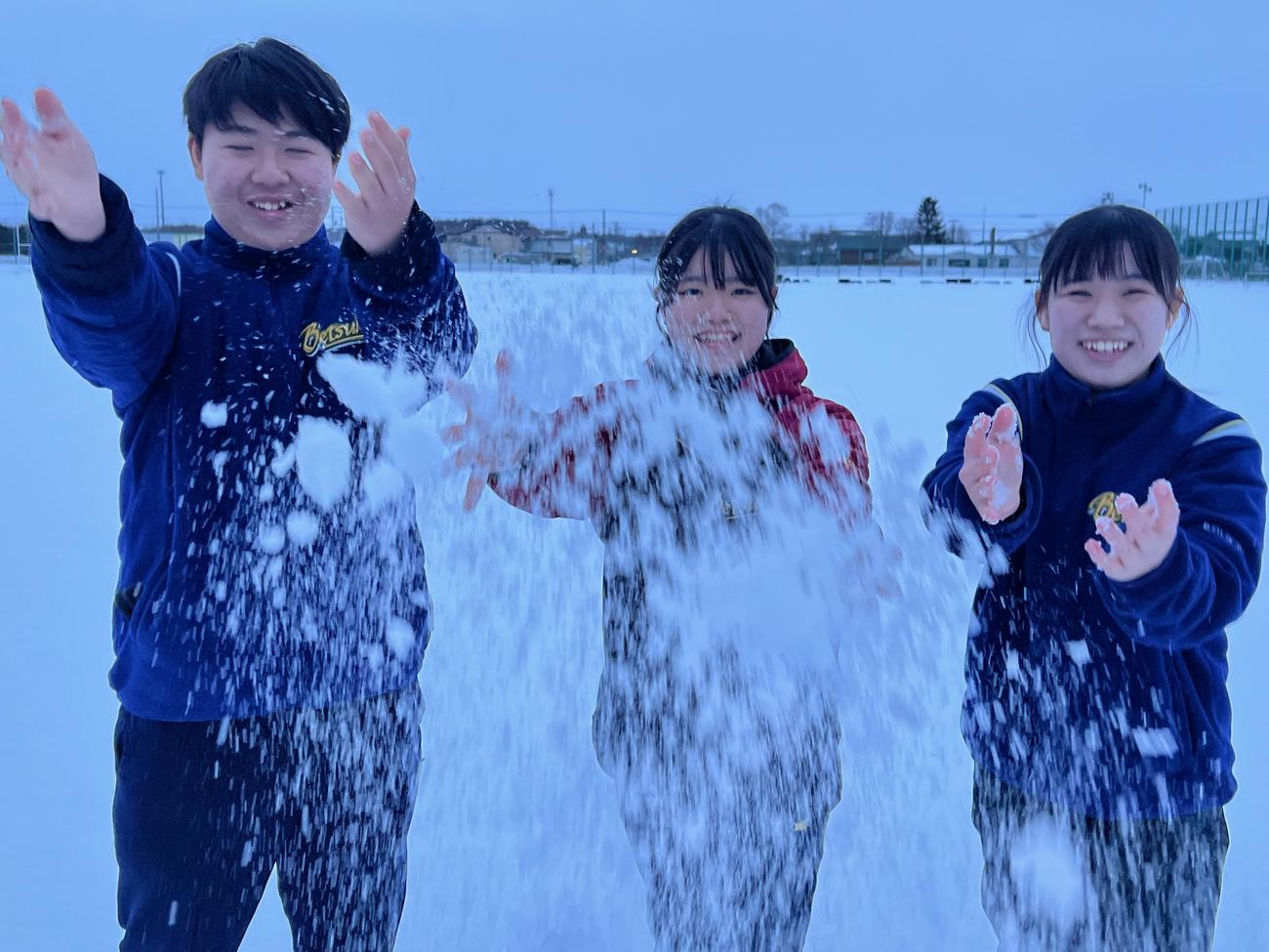 雪を投げる別海高校のマネジャー、左から坂野下瑛太、中岡真緒、藤倉梨緒（撮影・金子真仁）