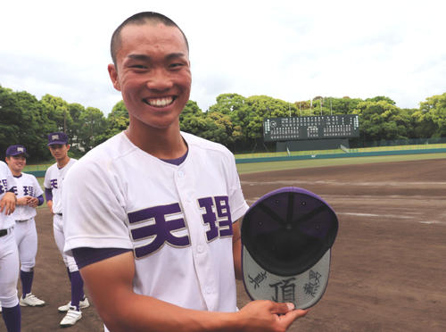 帽子のつばを見せる天理の背番号12永野