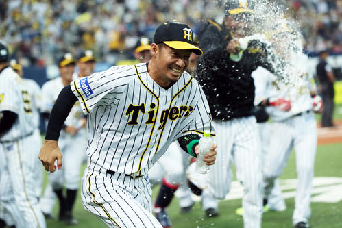 阪神対ヤクルト　11回裏阪神1死三塁、サヨナラ勝ちにつながる三塁打を放った鳥谷（手前）は、ナインにボトルを持って追い掛けられる（撮影・前田充）