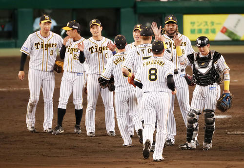 阪神対巨人　9回表に登板し無失点ピッチングで締めたドリス（右から2人目）はナインをハイタッチで迎える（撮影・加藤哉）