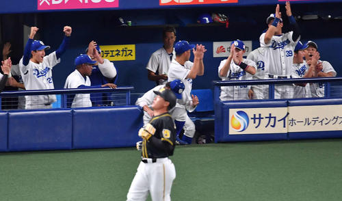 中日対阪神　9回表阪神2死、福留孝介（手前）の中飛でプロ初勝利をあげベンチでガッツポーズする梅津晃大（左）（撮影・上田博志）