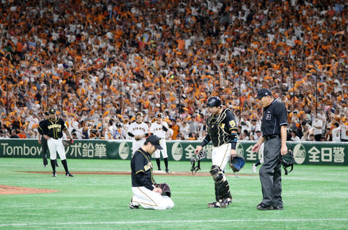 巨人対阪神　6回裏巨人2死三塁、西は丸にセーフティースクイズを決められて失点、座り込む。梅野（右）が声を掛ける（撮影・加藤哉）