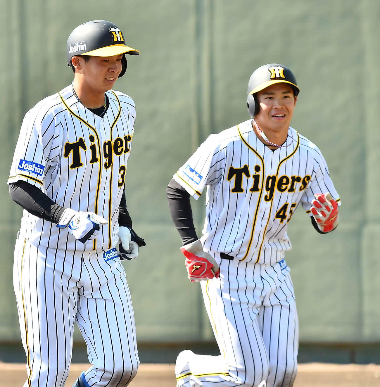阪神対ソフトバンク2軍戦　5回裏阪神1死三塁、中谷将大の適時内野安打で生還した遠藤成（右）は井上広大の出迎えに笑顔を見せる（撮影・上田博志）