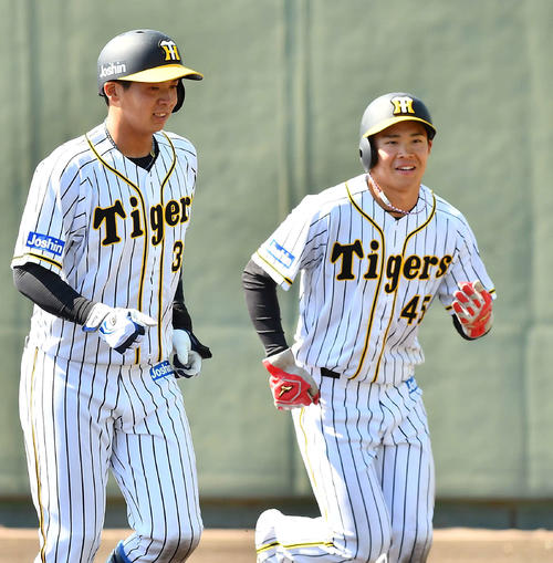 阪神対ソフトバンク2軍戦　5回裏阪神1死三塁、中谷将大の適時内野安打で生還した遠藤成（右）は井上広大の出迎えに笑顔を見せる（撮影・上田博志）
