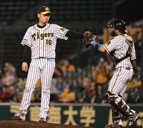 阪神対中日　完投勝利をあげ梅野（右）とタッチを交わす西勇（撮影・清水貴仁）