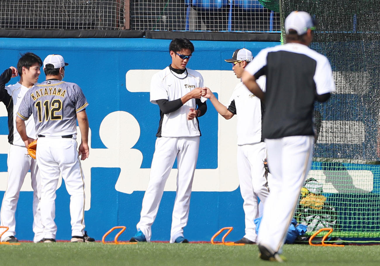 ヤクルト対阪神　練習中、金村コーチ（右）からグータッチを受ける藤浪（撮影・加藤哉）