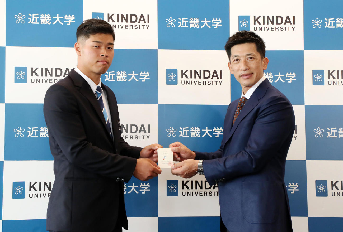 指名あいさつで交渉権獲得のカードを佐藤輝（左）へ手渡す矢野監督（撮影・加藤哉）