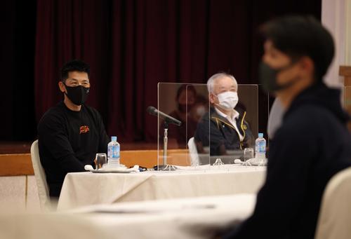 1軍全体ミーティングで選手の前に座る矢野燿大監督（左）と藤原崇起オーナー（球団提供）