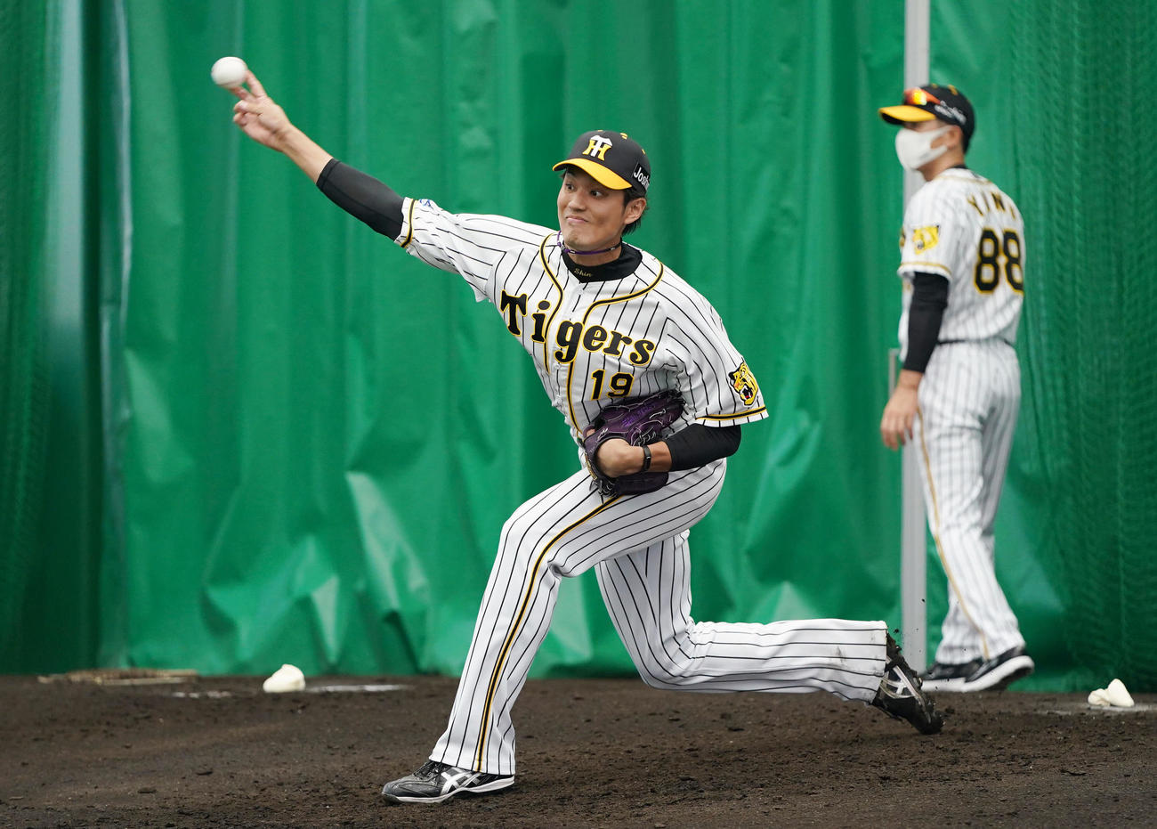 ブルペンで投球する阪神藤浪。右は矢野監督（撮影・前田充）