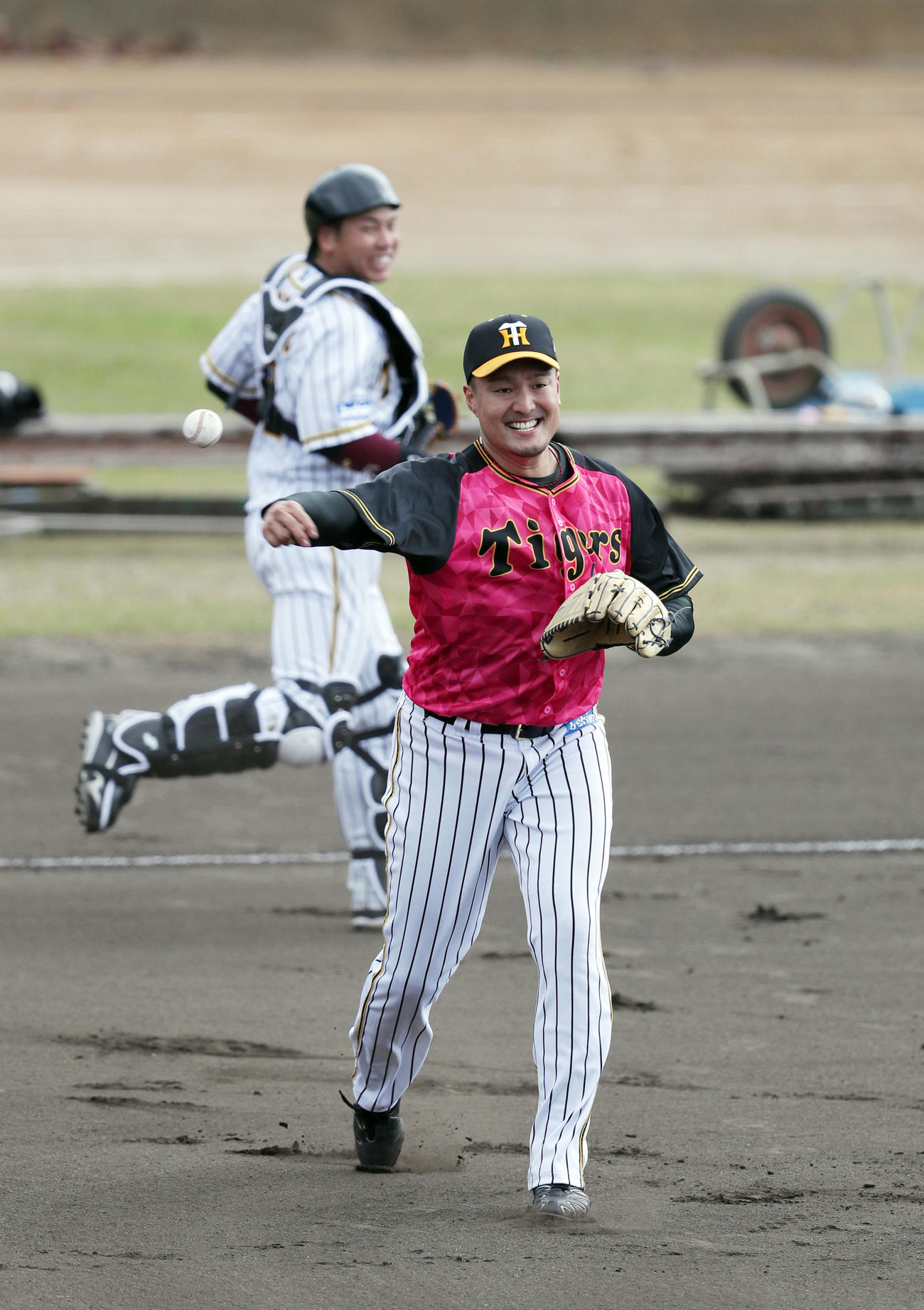 投内連係で笑顔を見せる阪神秋山。後方は梅野（撮影・前田充）
