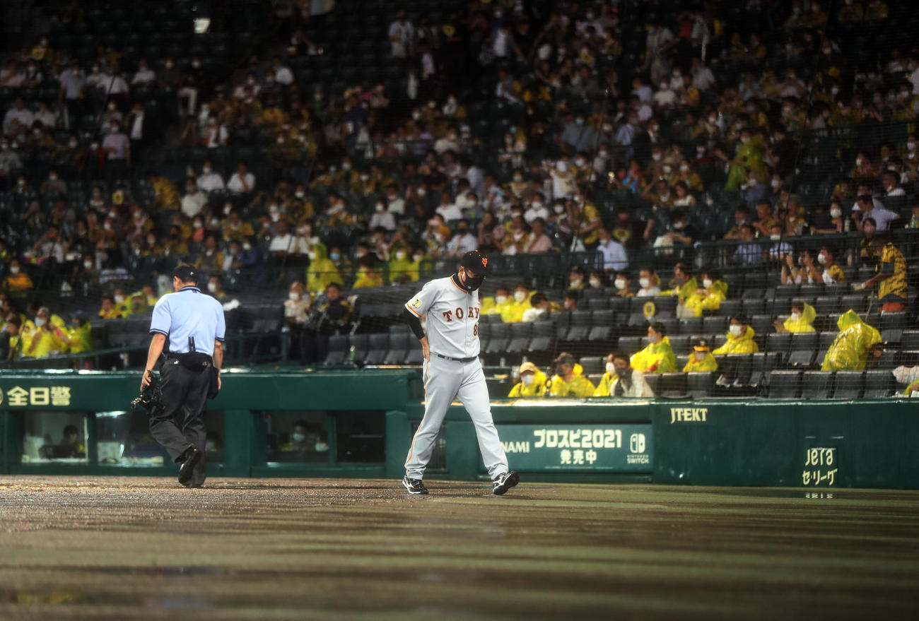 阪神対巨人　7回表途中、降雨により試合続行不能のためコールド負けが決定し、球審に説明を受けた後、引き揚げる原監督（撮影・狩俣裕三）