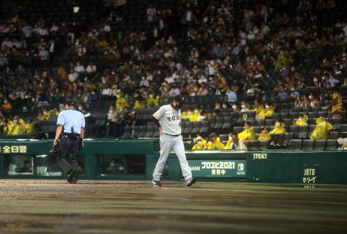 阪神対巨人　7回表途中、降雨により試合続行不能のためコールド負けが決定し、球審に説明を受けた後、引き揚げる原監督（撮影・狩俣裕三）