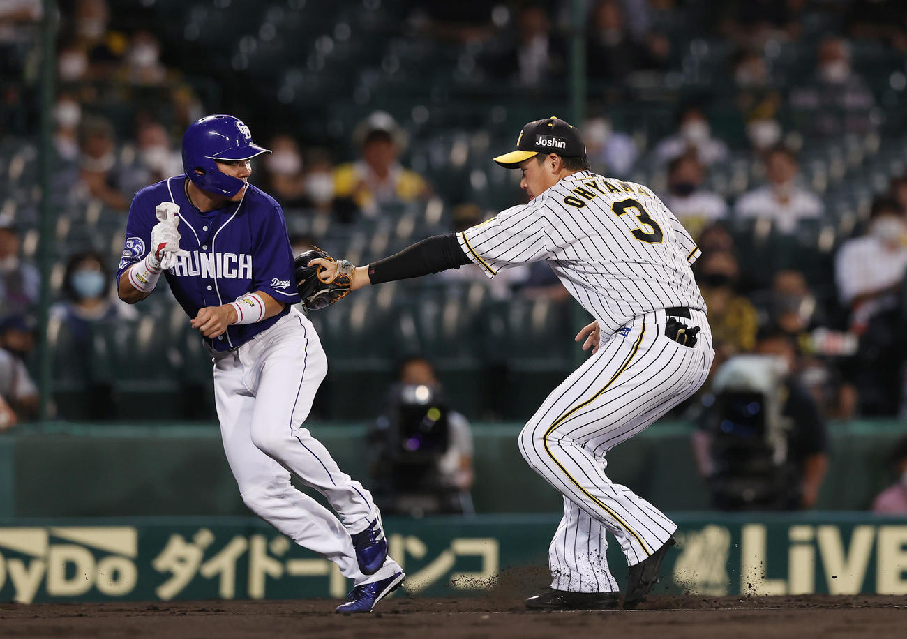 阪神対中日　4回表中日2死一、三塁、一走ビシエドが二盗を狙う間に飛び出した三走大島（左）は、捕手梅野から送球を受けた三塁手大山にタッチされアウトとなる（撮影・前田充）