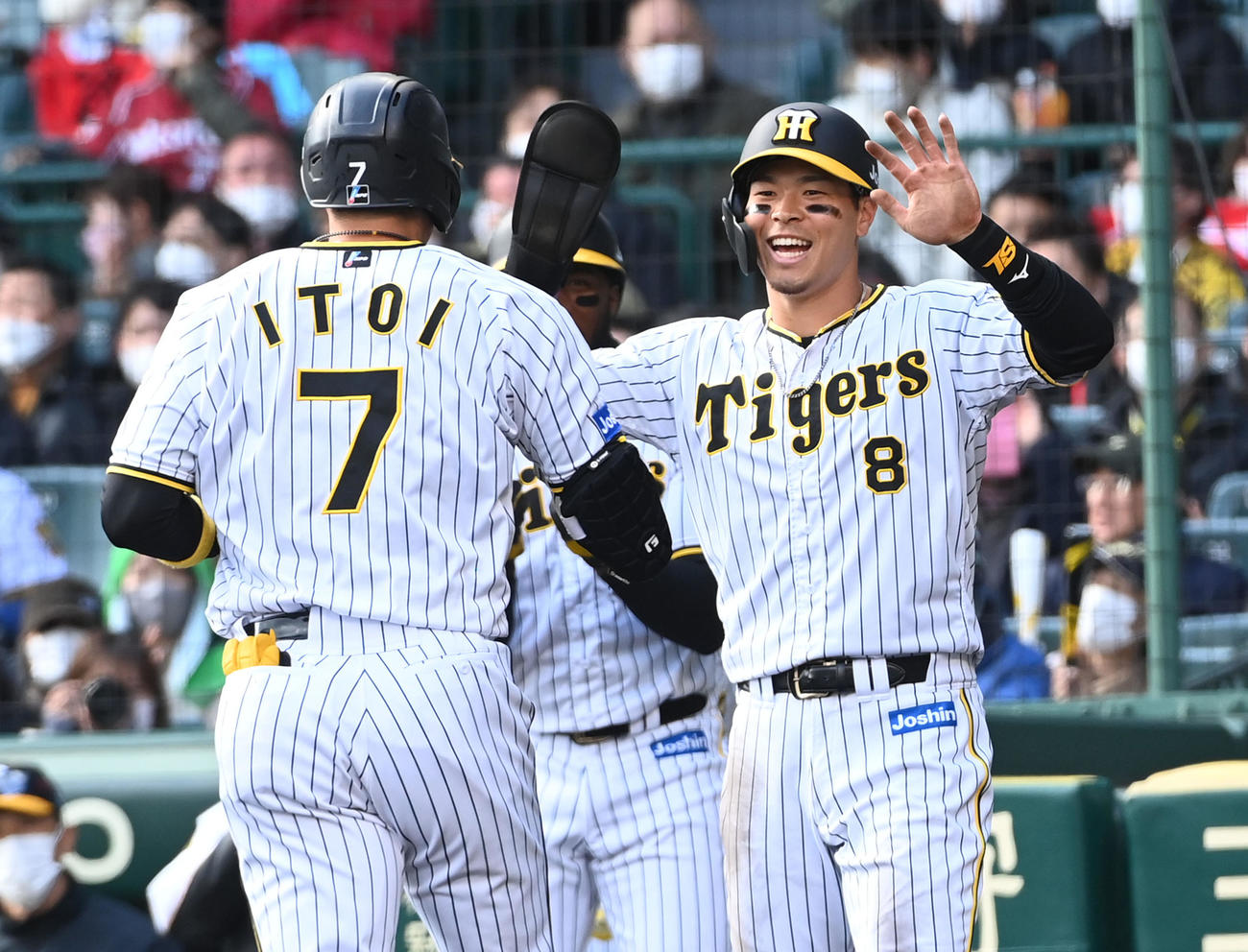 阪神対楽天　4回裏阪神1死二塁、バックスクリーンに2点本塁打を放った糸井（左）を笑顔で迎える佐藤輝（撮影・前岡正明）